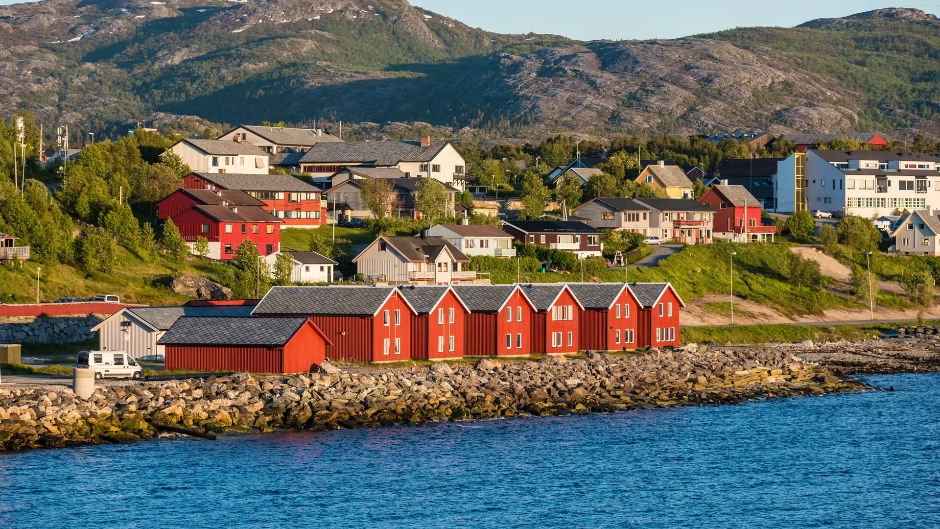 Red houses facades reflecting on the bay of Alta, Norway