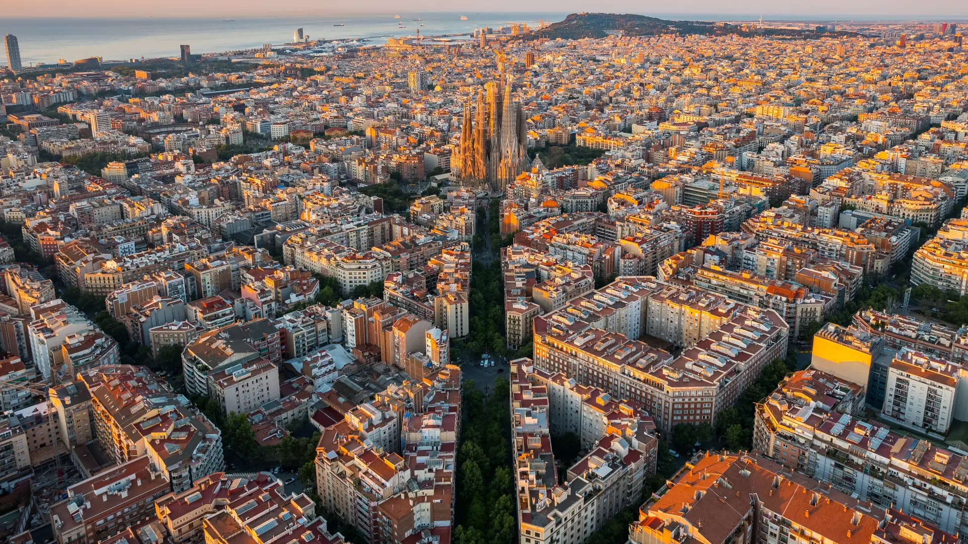 Aerial view of Barcelona Eixample residential district and Sagrada Familia Basilica at sunrise. Catalonia, Spain