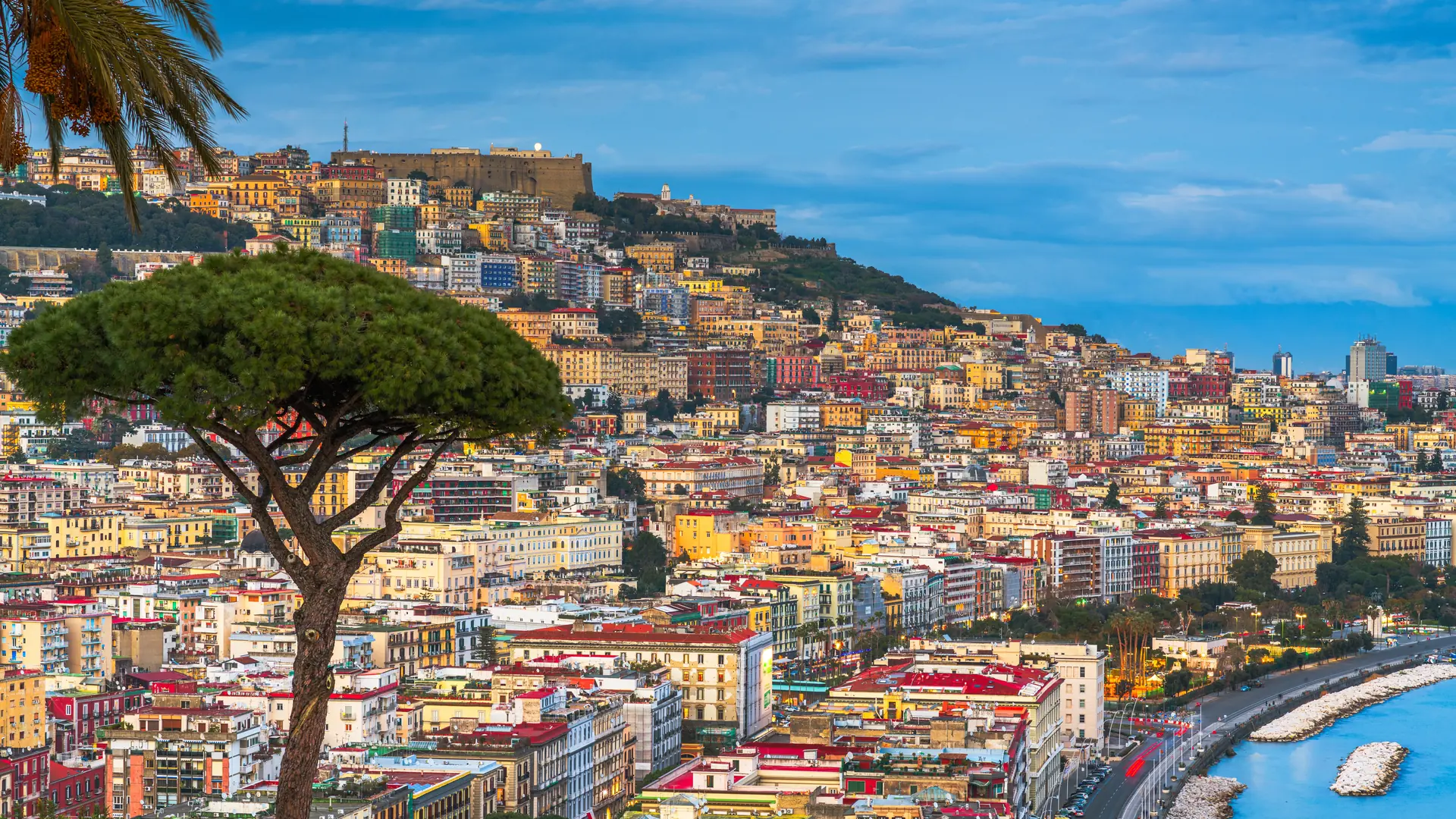 Naples, Italy along the Gulf of Naples at dusk.