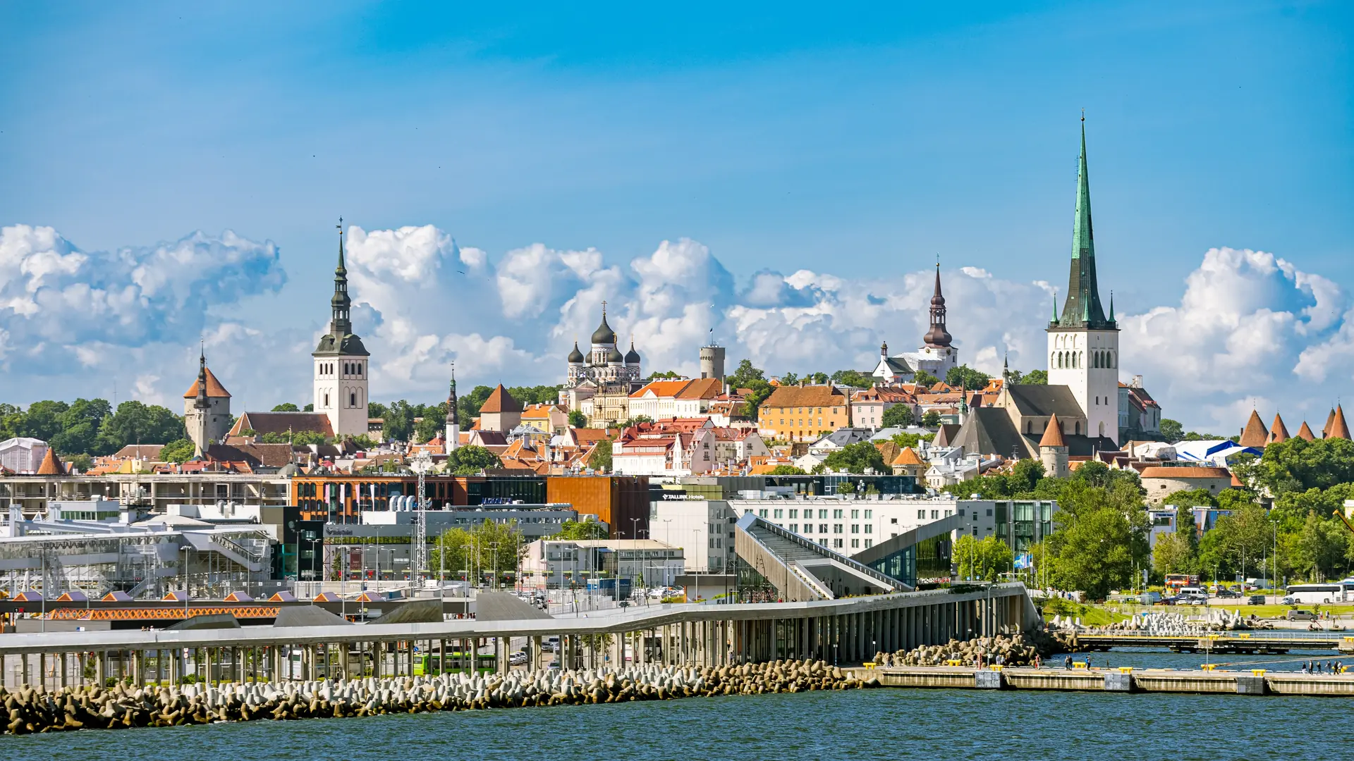 TALLINN, ESTONIA - JULY 09, 2025: A scenic view of Tallinns skyline from the sea, showcasing the historic Old Town with its numerous spires and domes on a hill, overlooking modern waterfront building